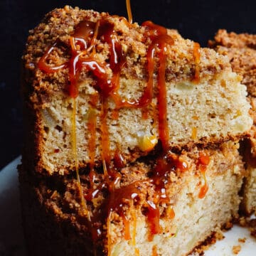 Caramel being poured over slices of apple cake stacked on each other.