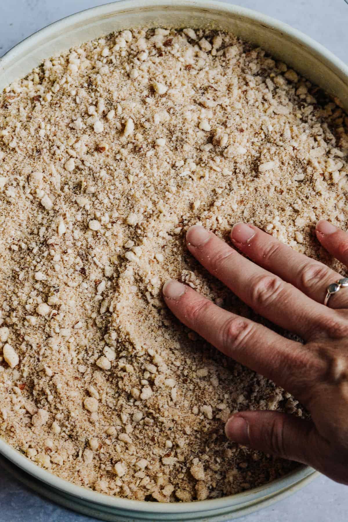 Crumb topping added to cake with hand spreading.