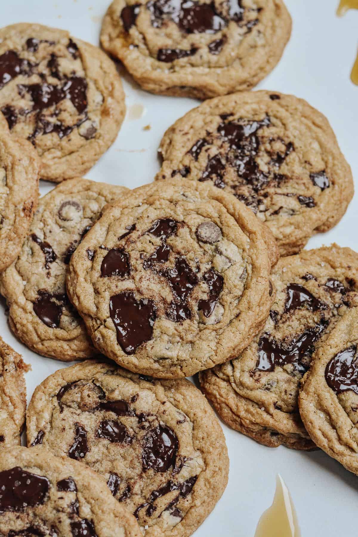 Lots of cookies on a marble counter with maple drizzled.